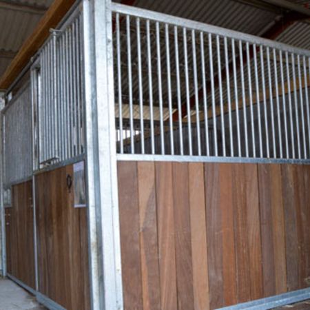 Stall für Pferde, ausgestattet mit Holzverkleidung und einem stabilen Metalltor