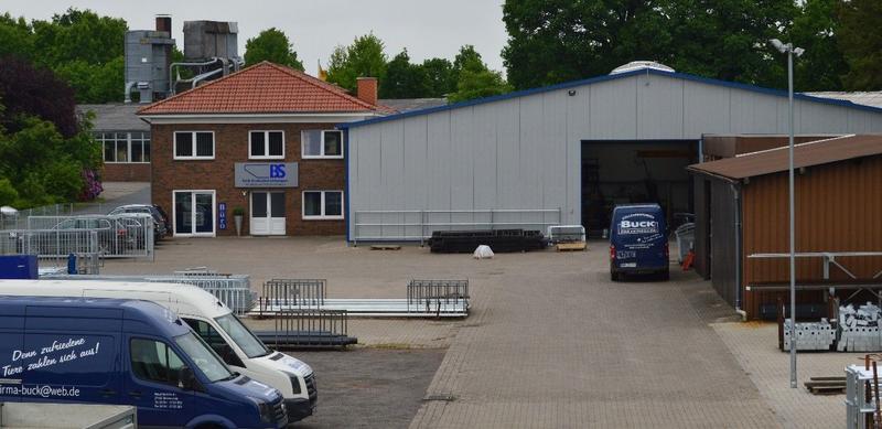 Buck Stalleinrichtung GmbH & Co. KG Hof Außenansicht | Ein großes Lagerhaus mit mehreren Lieferwagen, die davor geparkt sind